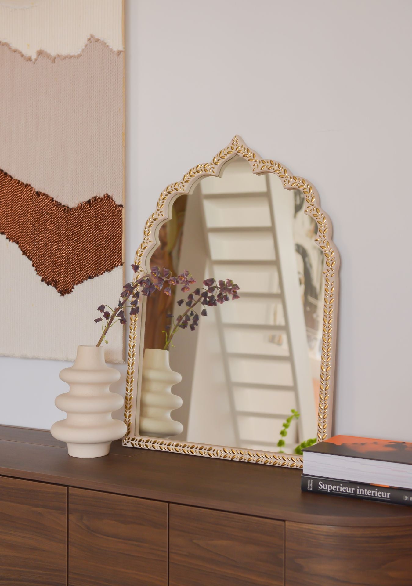 Handcrafted oriental mirror with golden mosaic frame on a wooden sideboard, styled with a ceramic vase and art book – Pure Reflection.
