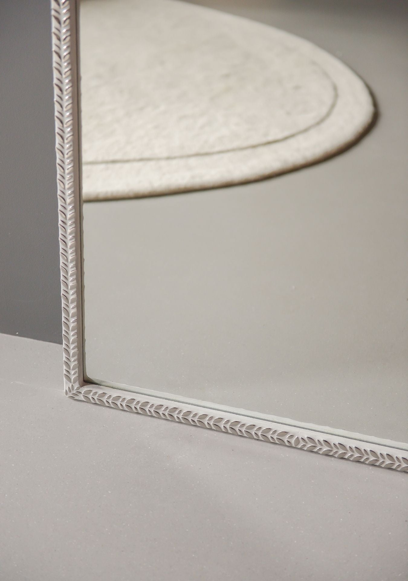 Close-up of silver mosaic craftsmanship and grout texture on the handmade designer mirror.