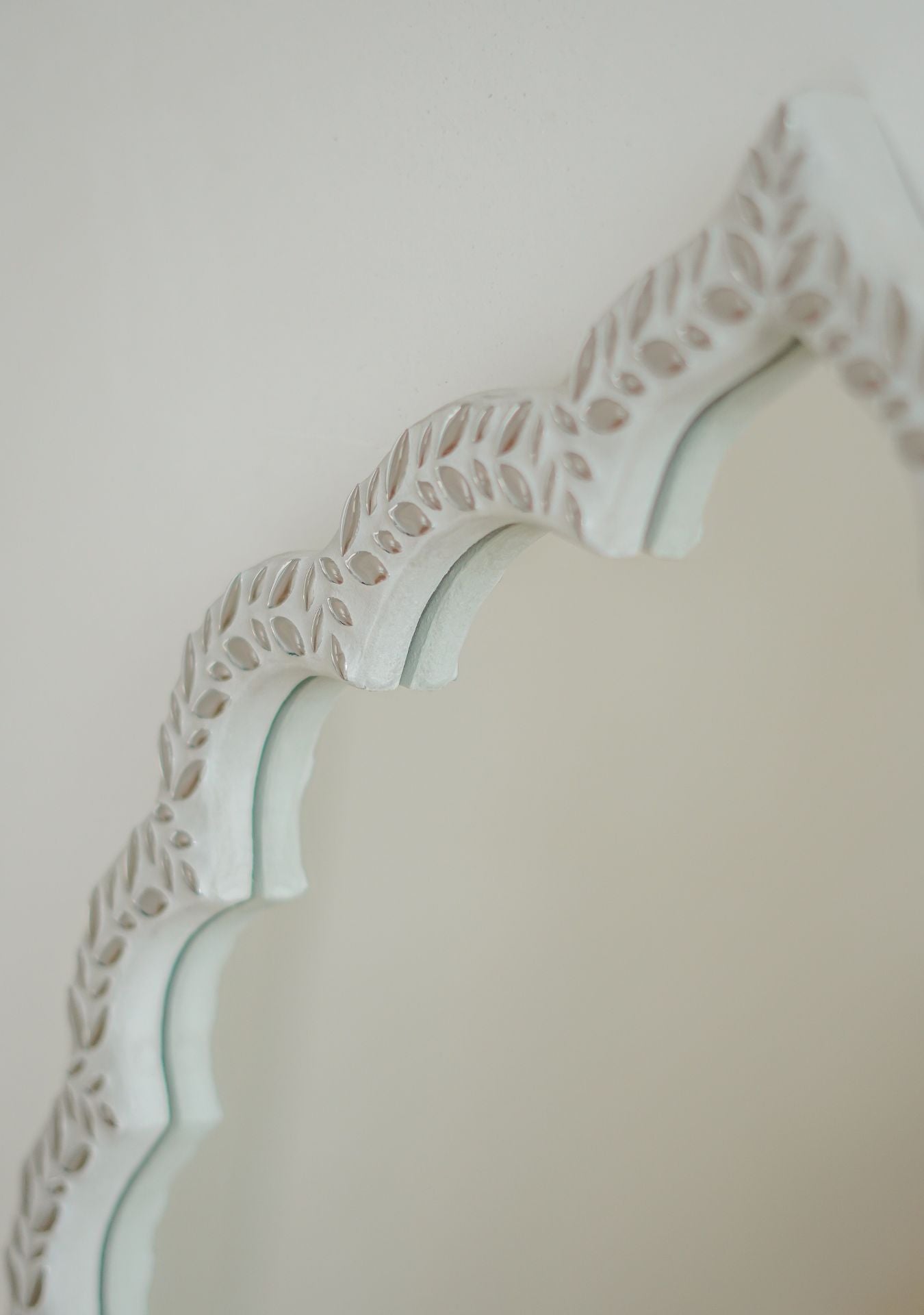 Close-up of the handcrafted mirror’s curved edge with white mosaic leaf detailing and elegant oriental design – Pure Reflection.