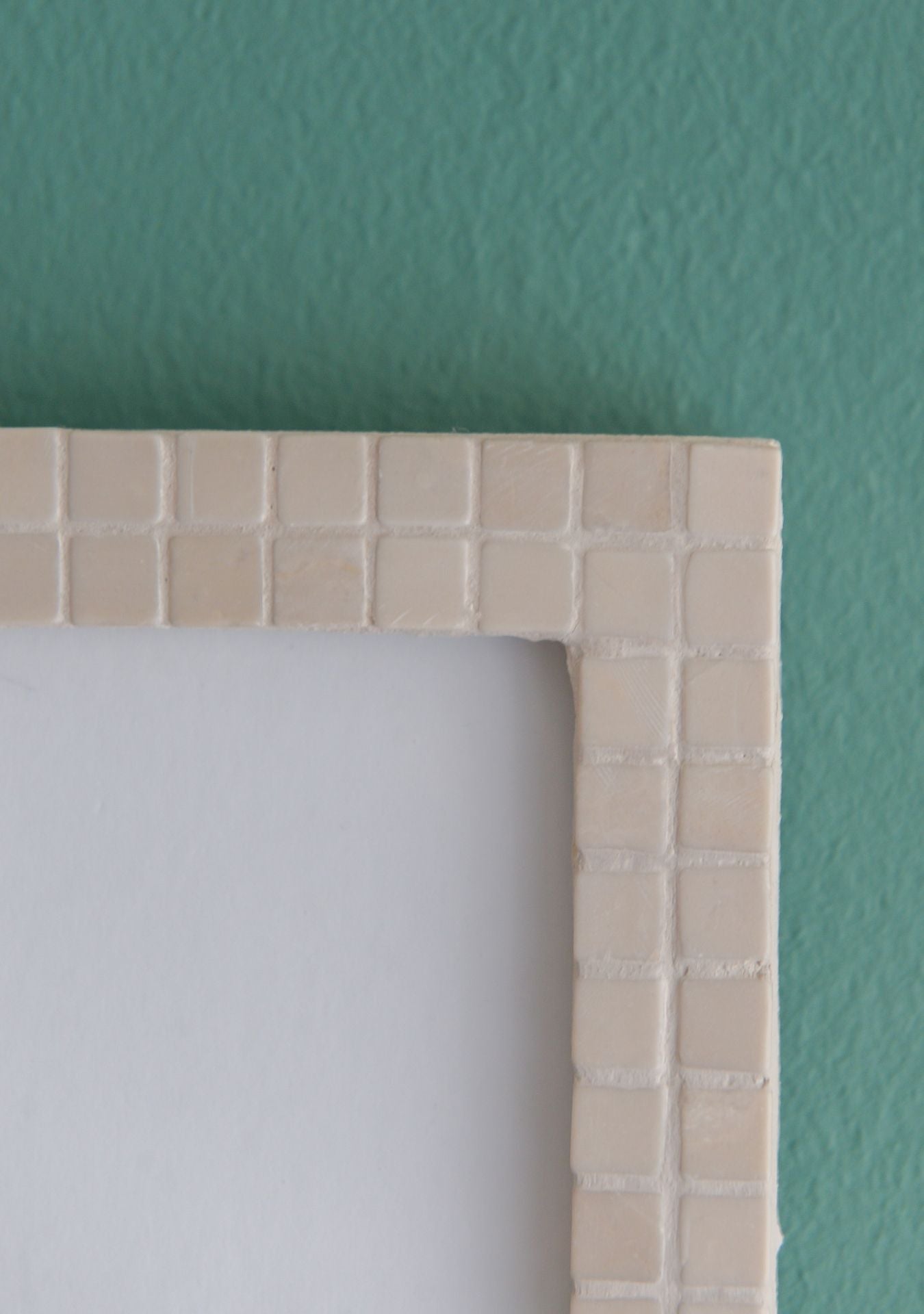 Close-up of beige mosaic photo frame edges and texture stones – Pure Reflection