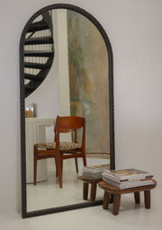 Handcrafted black arched mirror by Pure Reflection styled in an artistic modern interior.