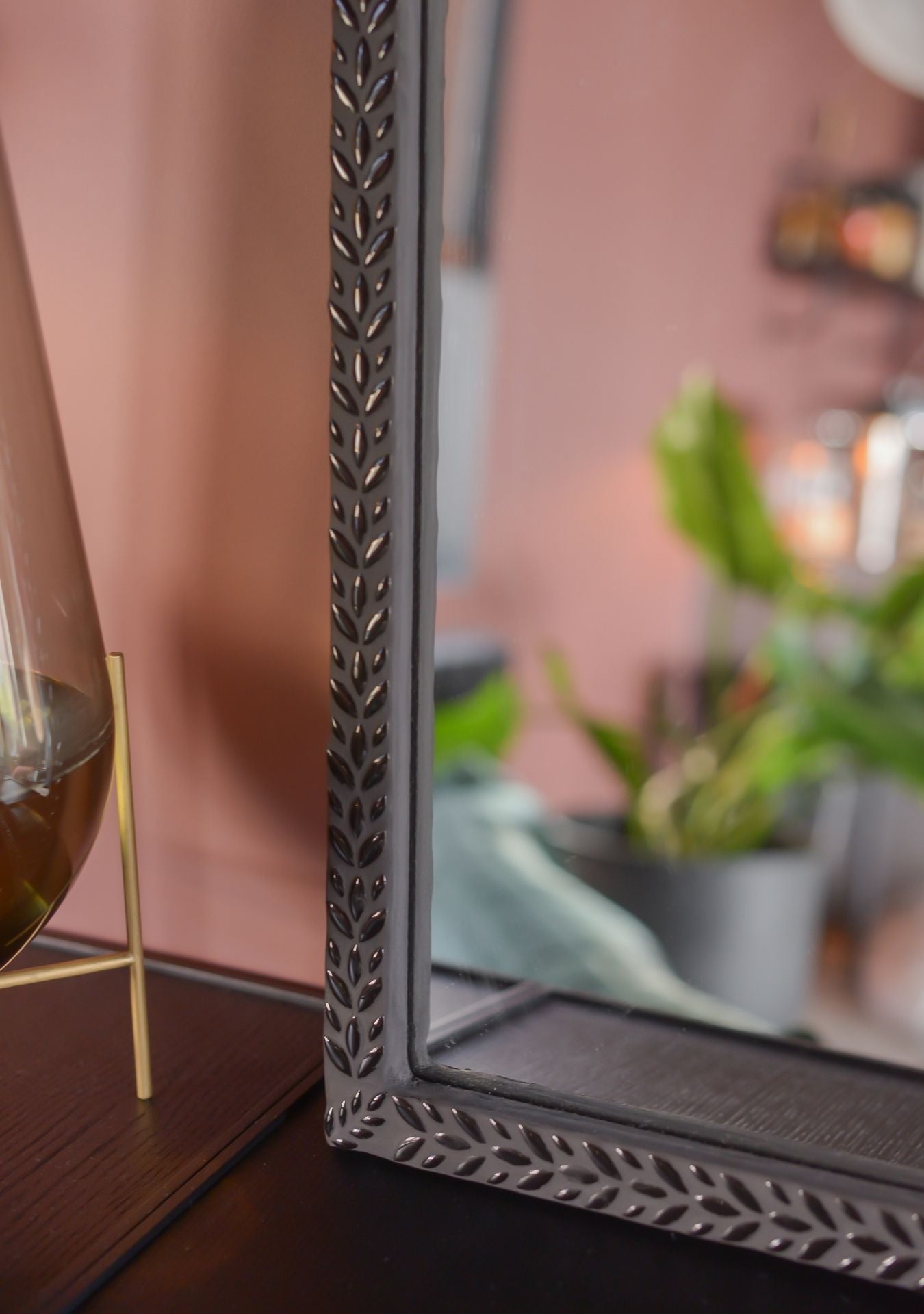 Close-up detail of the handmade mosaic mirror by Pure Reflection, showcasing the intricate leaf-patterned frame and refined craftsmanship in a warm interior setting.