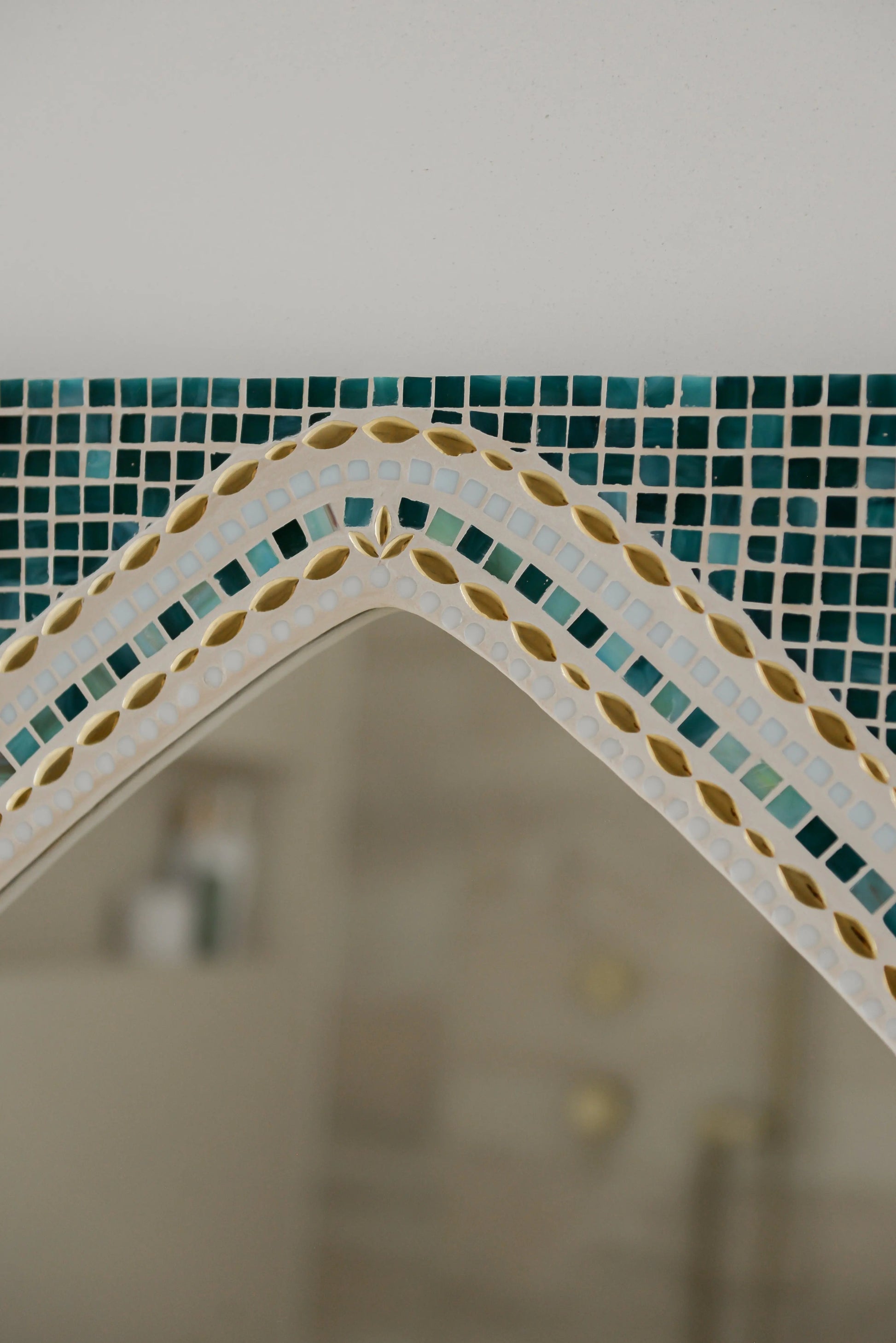 Detail shot of the top arch of Maraya Green mosaic mirror with intricate ceramic and glass design.