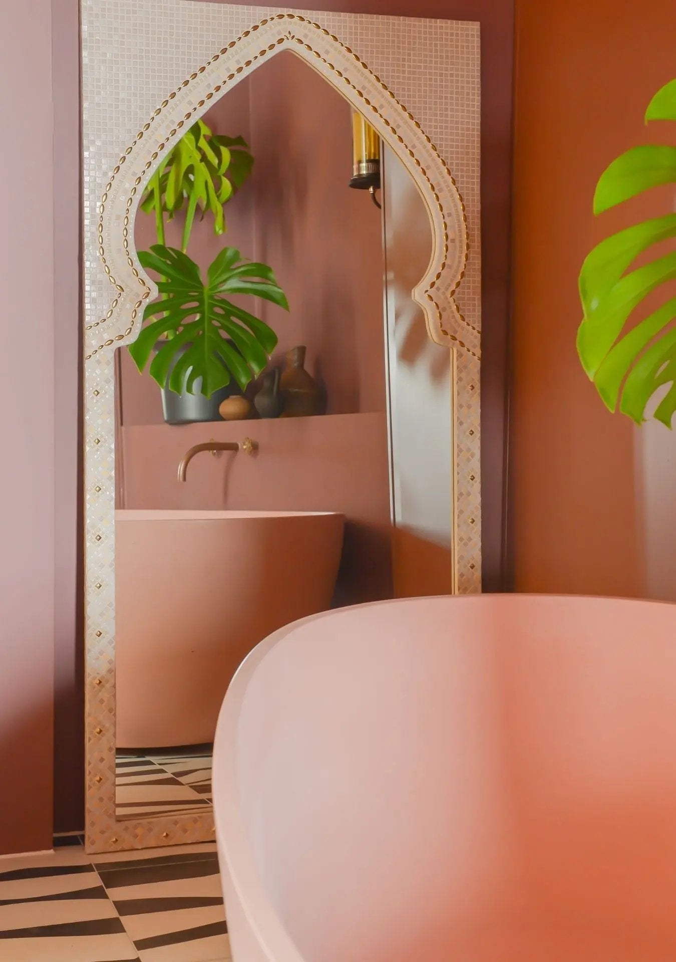 Elegant handmade mirror with blush mosaic stones and a timeless curved silhouette.