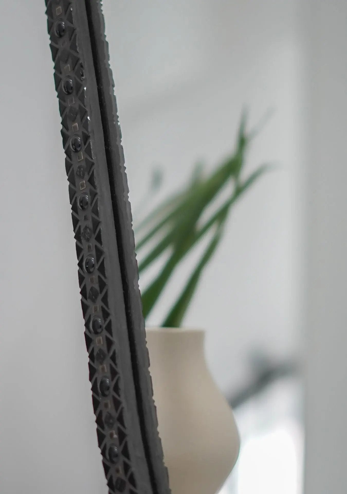 Close-up of handmade mosaic details and grout texture on the Mirror Ovalie Black in details.