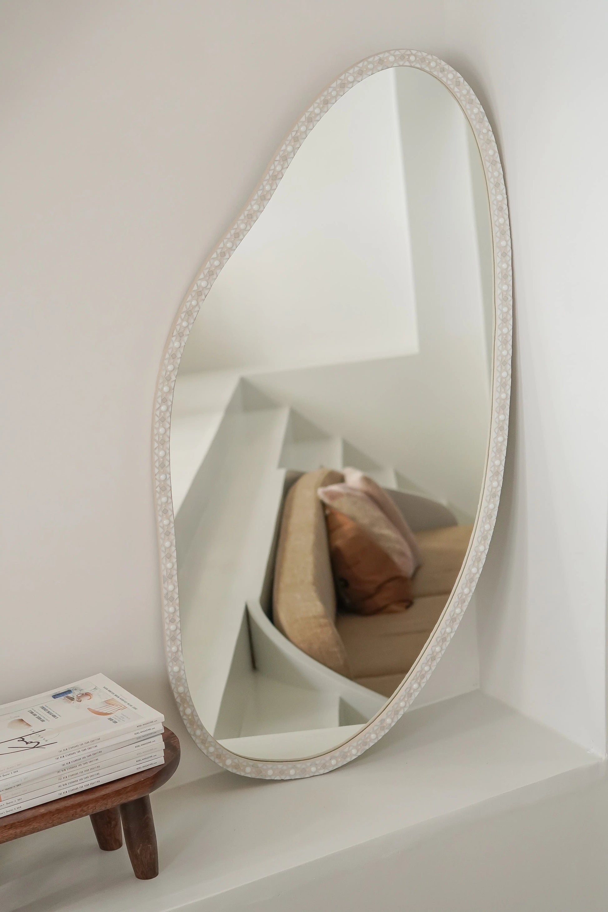 Handcrafted oval mosaic mirror in soft white tones made of glass, ceramic and grout.